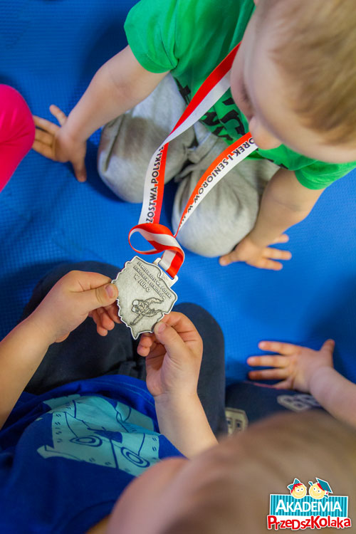 Przedszkolaki oglądają medal Wicemistrza Polski w judo