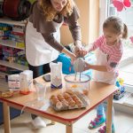 Ciocia pomaga przedszkolakowi miksować składniki na ciasto