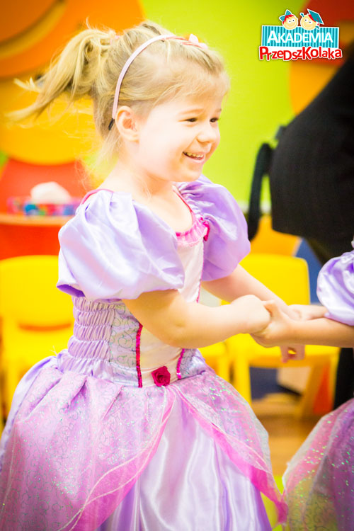 Przedszkolaczka w pięknej różowej sukni tańczy z drugą dziewczynką