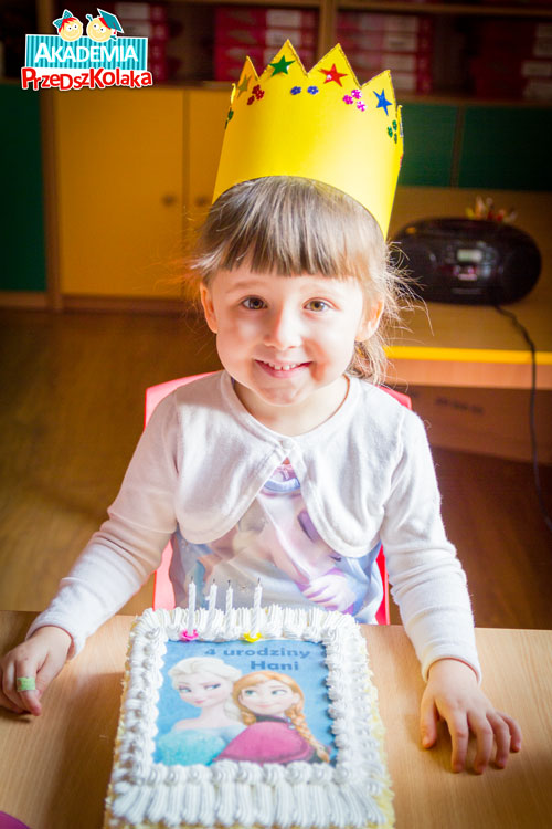 Przedszkolaczka razem ze swoim tortem urodzinowym